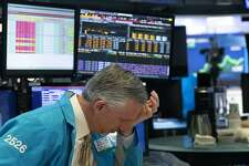 A trader holds his hand to his head after trading was halted at the New York Stock Exchange, Wednesday, March 18, 2020, in New York. (AP Photo/Mark Lennihan)