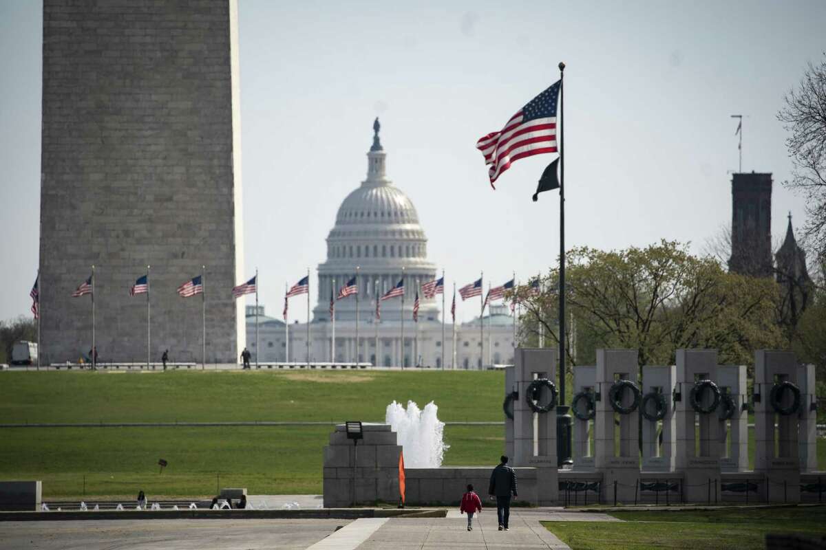 People walk by the drained Reflecting Pool on the National Mall in Washington, D.C., U.S., on Wednesday, March 18, 2020. Senate Majority Leader Mitch McConnell scheduled a vote Wednesday afternoon on the House bill responding to the economic fallout from the coronavirus pandemic and plans to immediately turn to a bigger stimulus package as the outbreak has the U.S. teetering on a recession. Photographer: Al Drago/Bloomberg