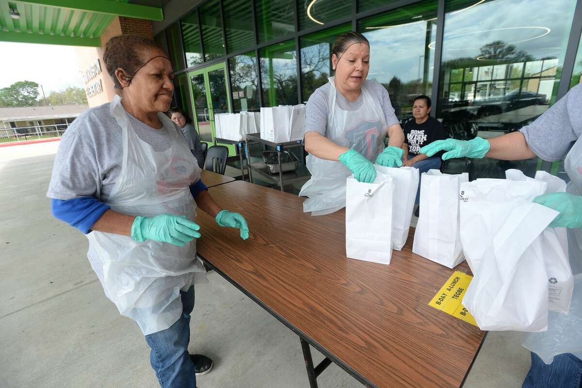 Lillian Ward and Maregarita Figuero help with the assembly line of sack lunches for distribution at Sam Houston Elementary on the first day of breakfast and lunch distribution for Port Arthur ISD students, as well as any children 18 and under who arrive to get a meal. Photo taken Wednesday, March 18, 2020 Kim Brent/The Enterprise