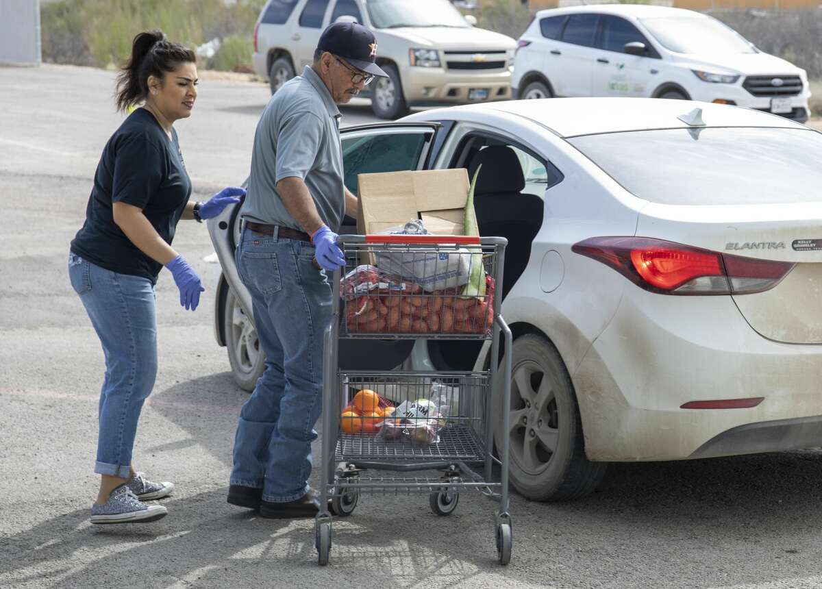 West Texas Food Bank employees Martha Carrasco, from left, and Eloy Salcido bring food from the pantry out to a car Wednesday, March 18, 2020 at the West Texas Food Bank in Odessa.