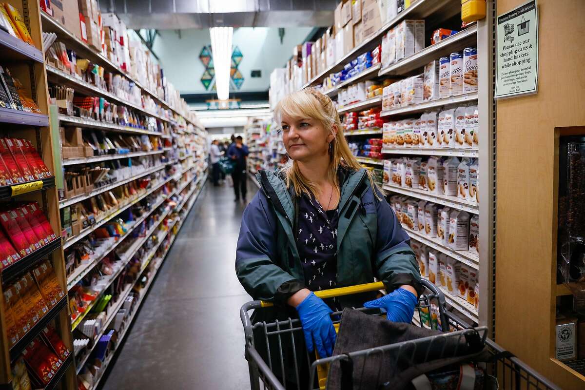 Oakland resident Shannon Ratay waits in line after shopping food for people in need at Berkeley Bowl on Sunday, March 15, 2020 in Berkeley, California. Ratay shopped for people who were in need of food but could not leave their house due to the coronavirus.