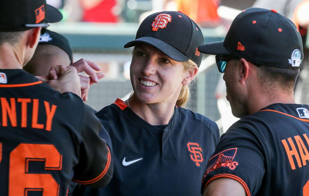 San Francisco Giants' coach Alyssa Nakken gets a fist bump from Rob Brantly before their game with the Cleveland Indians at Scottsdale Stadium Thursday, March 5, 2020, in Scottsdale, Arizona.