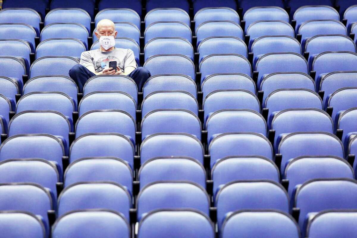 Mike Lemcke, from Richmond, Va., sits in an empty Greensboro Coliseum after the NCAA college basketball games were canceled at the Atlantic Coast Conference tournament in Greensboro, N.C., Thursday, March 12, 2020. The sweeping suspension of sports due to concern over the coronavirus has affected Michigan high school athletics as well, including in Manistee County.  (AP Photo/Ben McKeown)