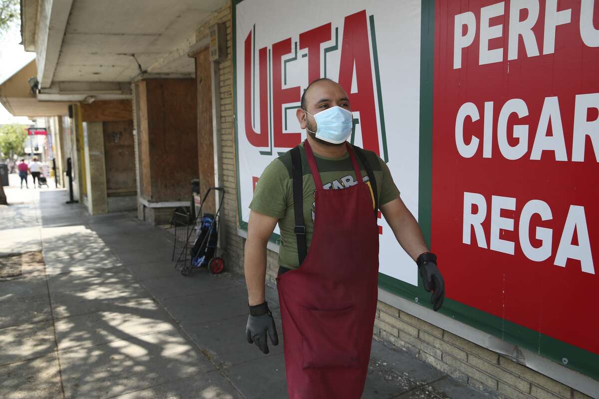 Adrian Torrez, 41, wears protection as he walks between stores in downtown Laredo, Texas, Wednesday, March 18, 2020. Torrez, who works at a shoe retail and wholesale business said he has seen a drop in business in response to the coronavirus threat. The majority of businesses in the downtown area sell to the Mexican market. He said that his boss required them to wear the protective gear.