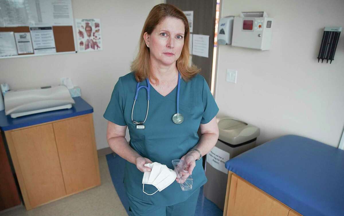 Dr. Christina Propst holds the mask and goggles that she reuses in her pediatric practice in Houston.