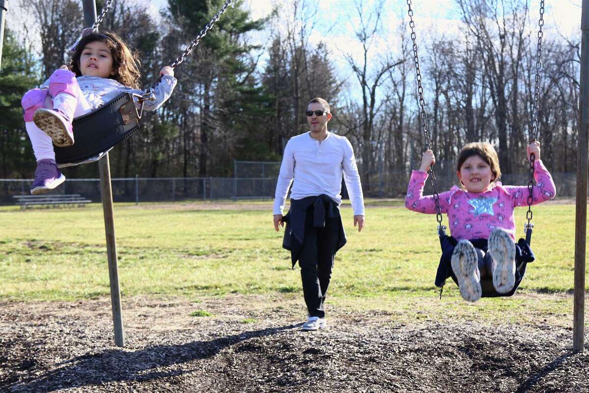 Chuck Householder of Wilton enjoys some time with his girls Nicole, 4, left, and Brooke, 7, at Miller-Driscoll School Friday afternoon.
