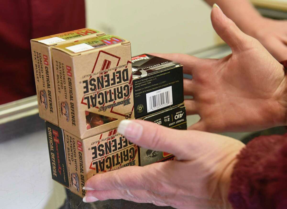 A customer grabs her purchase of ammunition at Upstate Guns & Ammo store on Thursday, March 19, 2020 in Schenectady N.Y. (Lori Van Buren/Times Union)