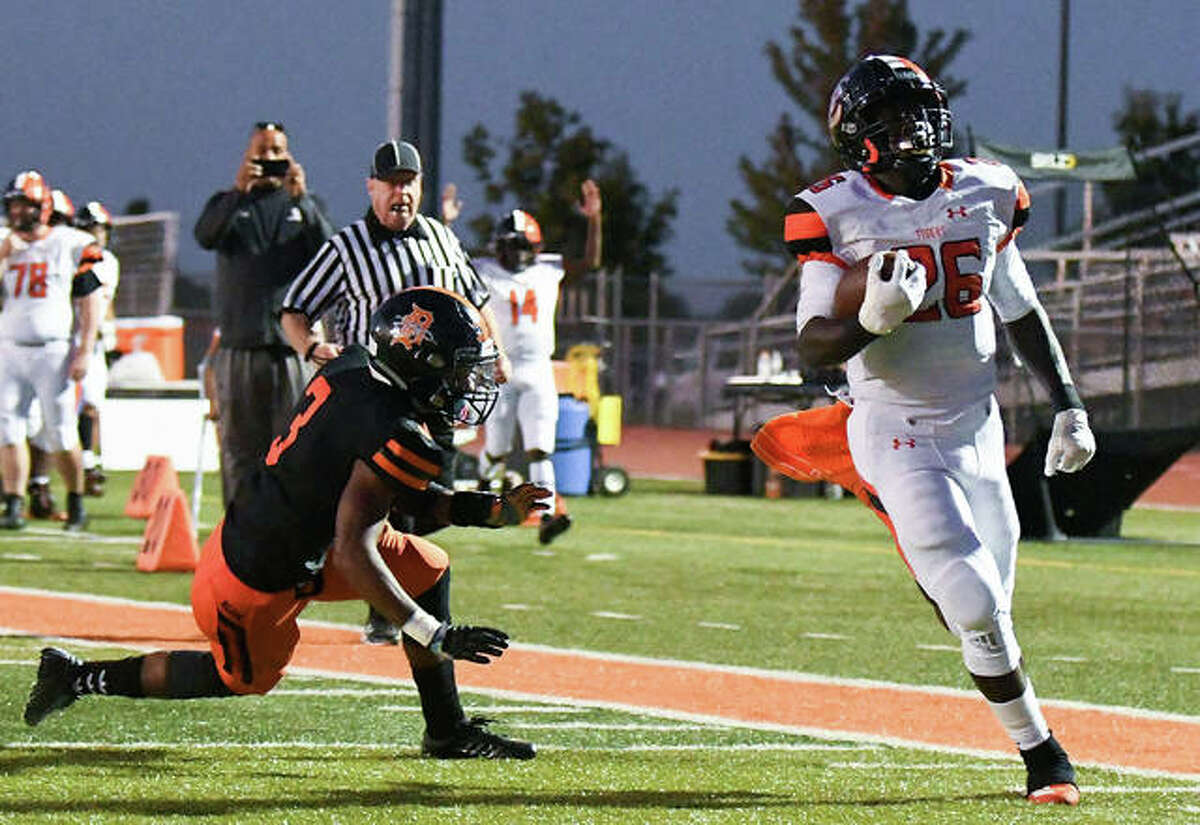 Edwardsville’s Justin Johnson Jr. (26) runs in for a touched and out of reach of DeKalb’s Cameron Grays (3) in action last season at the District 7 Sports Complex
