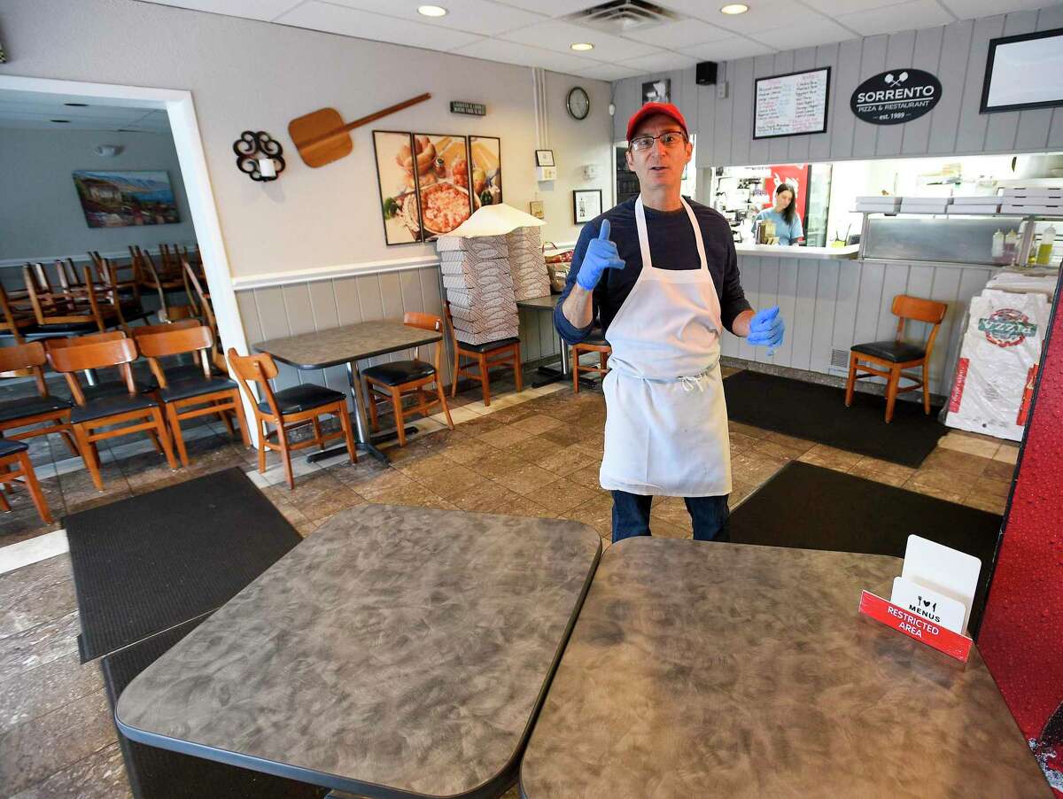 Owner Tony Uva of Sorrento Pizza and Restaurant on High Ridge Road, stands behind a table barrier he has set up to prevent his customers from entering his business to pick up take out orders. Uva talks about changes he has made in his family owned business of 31 years, in direct response to the COVID-19 crisis and what he is doing to safely serve his customers and fulfill take out orders in a safe manner on March 19, 2020 in Stamford, Connecticut.