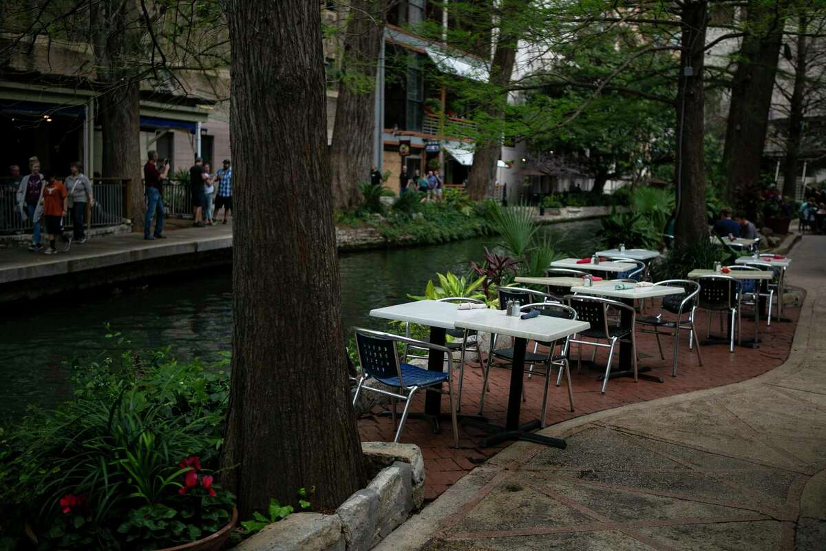 Empty tables line the river outside the County Line restaurant. The River Walk has become a much quieter place these days.