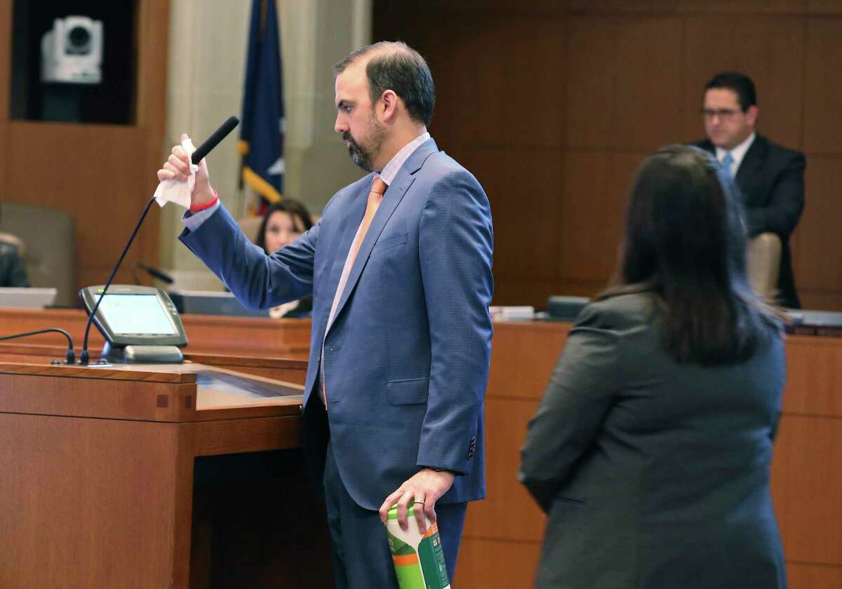 John Petered, assistant to the city manager, wipes down the microphone and lectern as Mayor Ron Nirenberg and the City Council gather to discuss extending the latest Coronavirus emergency declaration to 30 days on Thursday, Mar. 19, 2020. Two council members: District 8's Manny Peláez and District 3's Rebecca J. Viagran were present via video-conferencing since both are self-quarantining from their homes. The meeting was held under attendance restriction on no more than 50 people and seating in the room observed social distancing with signage included.