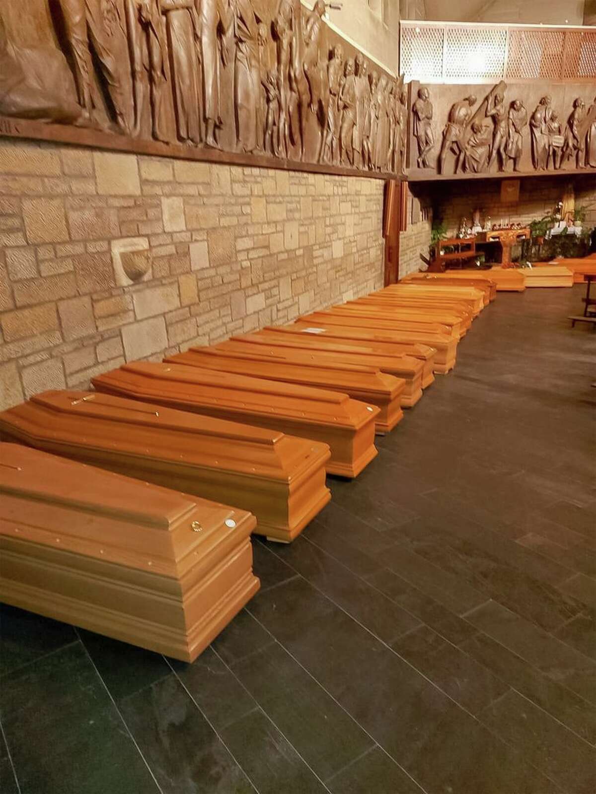 This photo provided by Italian news agency ANSA on March 19, 2020 shows coffins aligned in a chapel in Bergamo, Lombardy on March 18, 2020 prior to being transported for cremation.