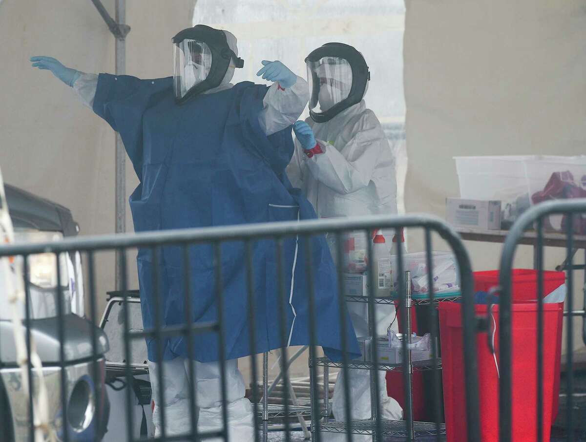 Medical personnel from Murphy Medical Associates administer drive-thru screenings for the Covid-19 coronavirus at a mobile testing site set up at Cummings Beach in Stamford, Conn. , March 20, 2020.