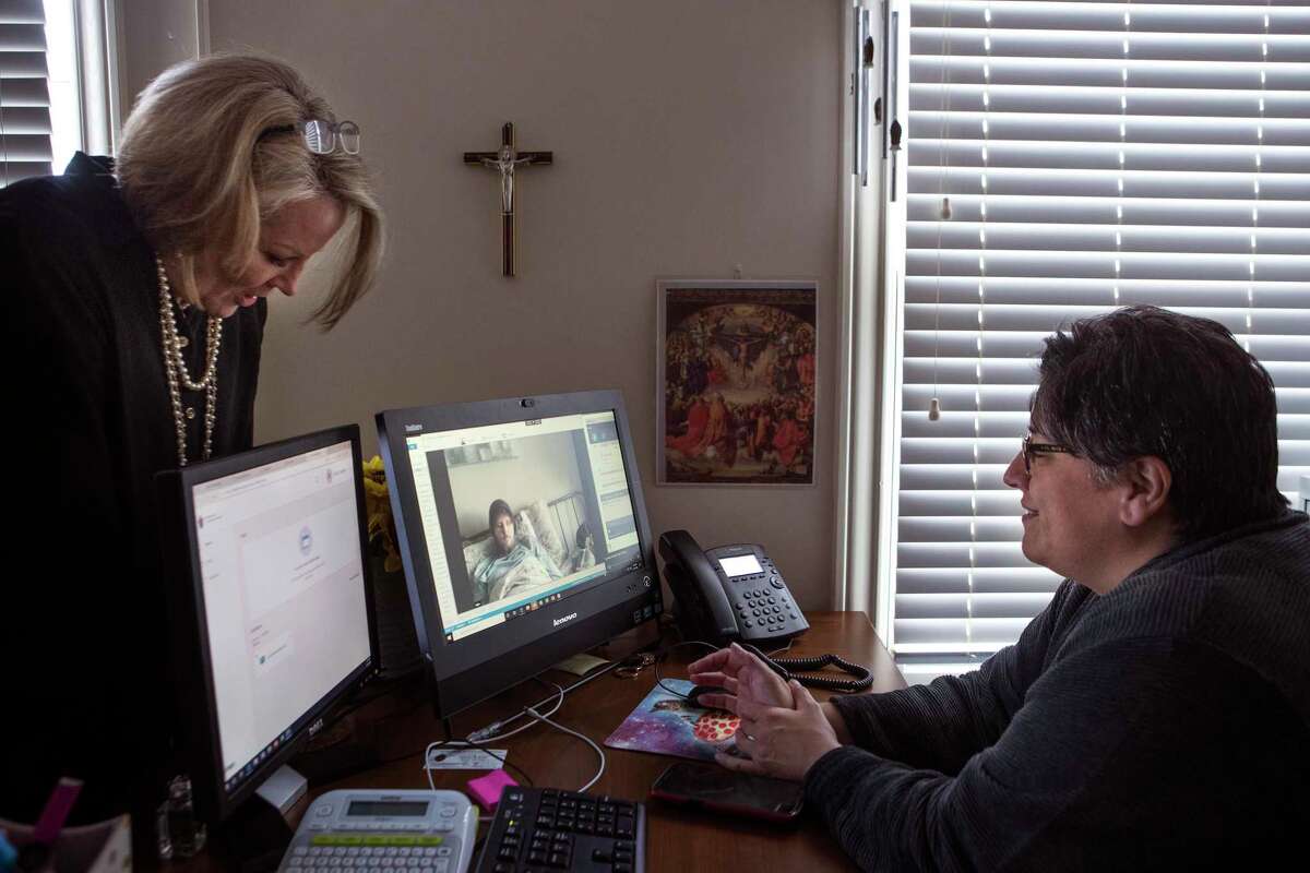 Denice Fooce, director Catholic Chaplain Corps, left, and Dawn Malone, a lay chaplain for the archdiocese of Galveston-Houston, minister to cancer patient Austin Bond, via video conference on Thursday, March 19, 2020 in Houston. Coronavirus has limited local chaplains the ability to minister to the sick or elderly. Chaplains have also been told not to minister to any group more than 10.