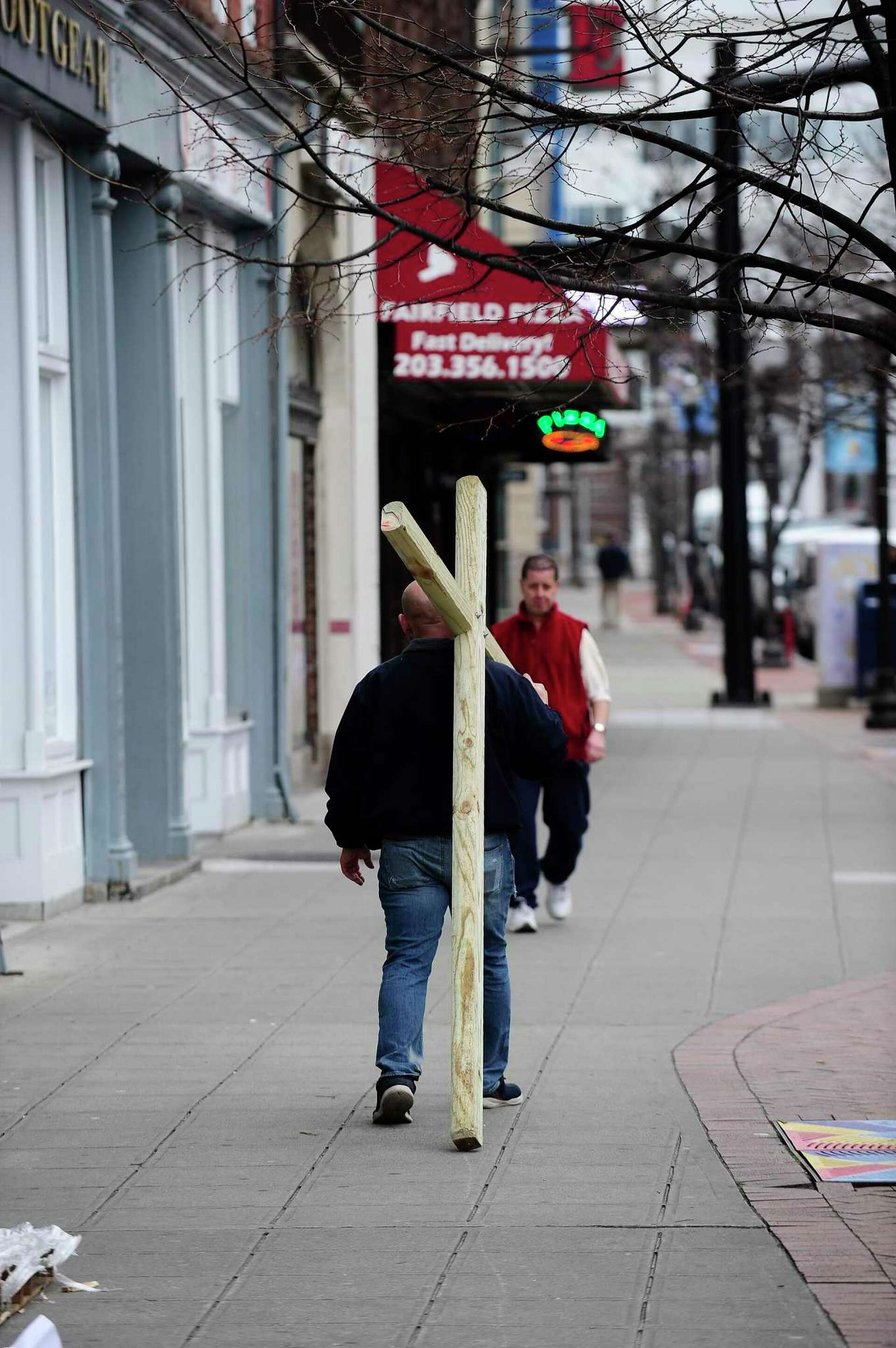 See a reverend who is carrying a wooden cross to spread peace