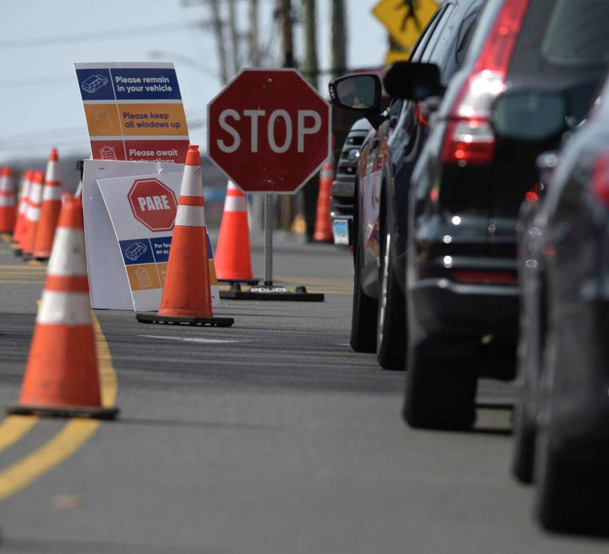 Cars wait in line at a drive-thru testing site for the respiratory virus known as COVID-19 that has been setup in one of Danbury Hospitals parking garages. The Danbury Police Department is controlling the flow of traffic to the street. Wednesday, March 18, 2020, in Danbury, Conn.