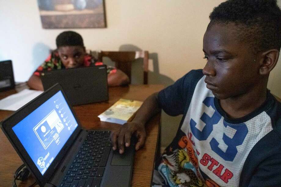 TaeChaun Jeffries, 15, and his brother, Sancell Jeffries-Johnson  14 look over their Chromebook computers Thursday. The devices were loaned to them for home use during the coronavirus crisis by the Southwest Independent School District, but the family has no internet connection. As schools switch to online learning, San Antonio’s digital divide is widening. Photo: Billy Calzada, San Antonio Express-News / Billy Calzada / ***MANDATORY CREDIT FOR PHOTOG AND SAN ANTONIO EXPRESS-NEWS /NO SALES/MAGS OUT/TV