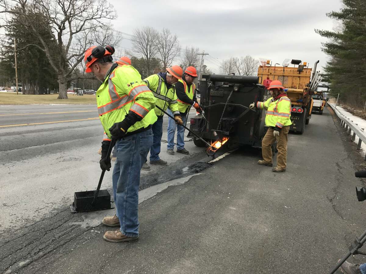 NYS Department of Transportation work crews use mastic to fix potholes on Route 9 near Round Lake in February.