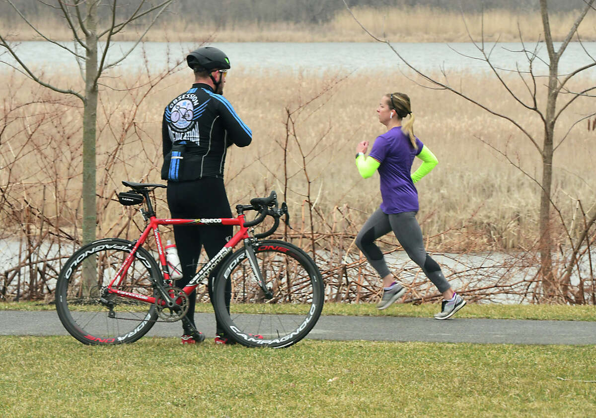 A bicyclist takes a break from riding as a jogger passes by him on the Mohawk-Hudson bike/hike trail on Friday, March 20, 2020 in Niskayuna, N.Y. (Lori Van Buren/Times Union)
