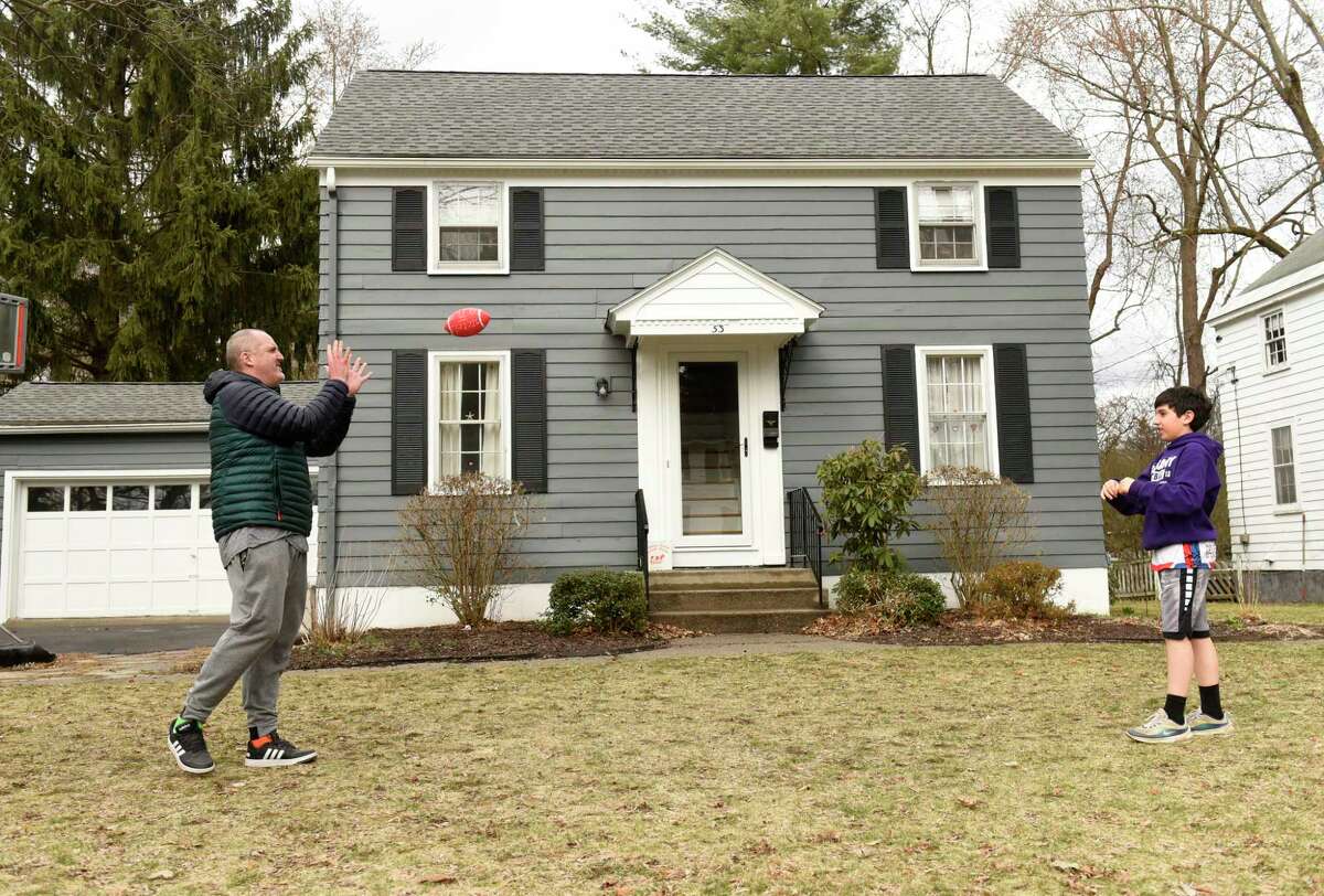 Larry Rulison, who is immune-compromised, throws a football in his front yard with his son Jack, 10, to get some exercise in on Friday, March 20, 2020 in Delmar, N.Y. His kids are homeschooling and Larry is working from home amid COVID-19 crisis. (Lori Van Buren/Times Union)