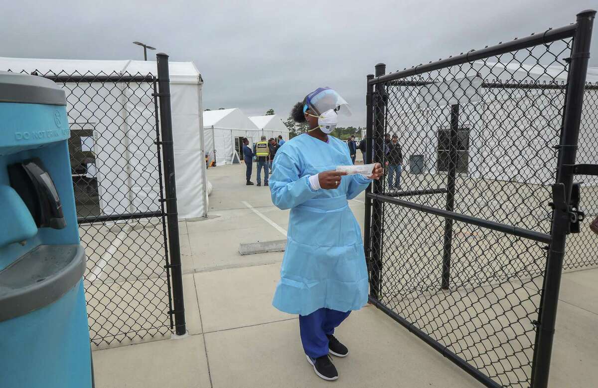 Harris County Public Health Harriett Lewis LVN comes out to demonstrate her role during a media tour of a COVID-19 testing site where first responders and medical staff who have symptoms and have been pre-authorized to test Saturday, March 21, 2020, in Houston. Harris County Public Health and Houston Health Department and are not identifying the locations of the sites to prevent people from showing up and being turned away.