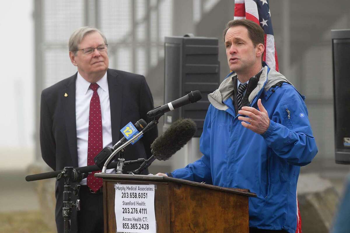 Stamford Mayor David Martin listens as Congressman Jim Himes speaks at a press conference as medical personnel from Murphy Medical Associates administer drive-thru screenings for the Covid-19 coronavirus at a mobile testing site set up at Cummings Beach in Stamford, Conn. , March 20, 2020.