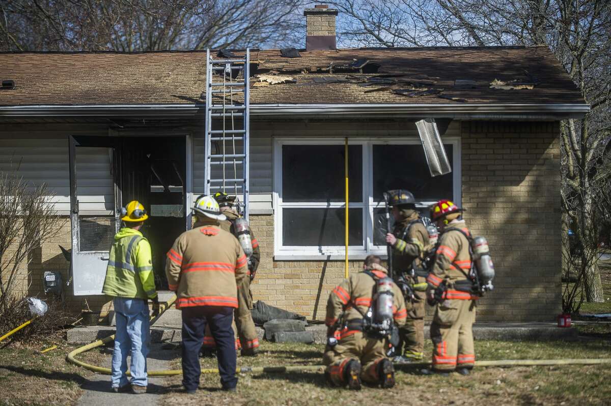 Firefighters with the Midland Fire Department secure the scene of a house fire at 3418 Sharon Street Saturday, March 21, 2020 in Midland. (Katy Kildee/kkildee@mdn.net)