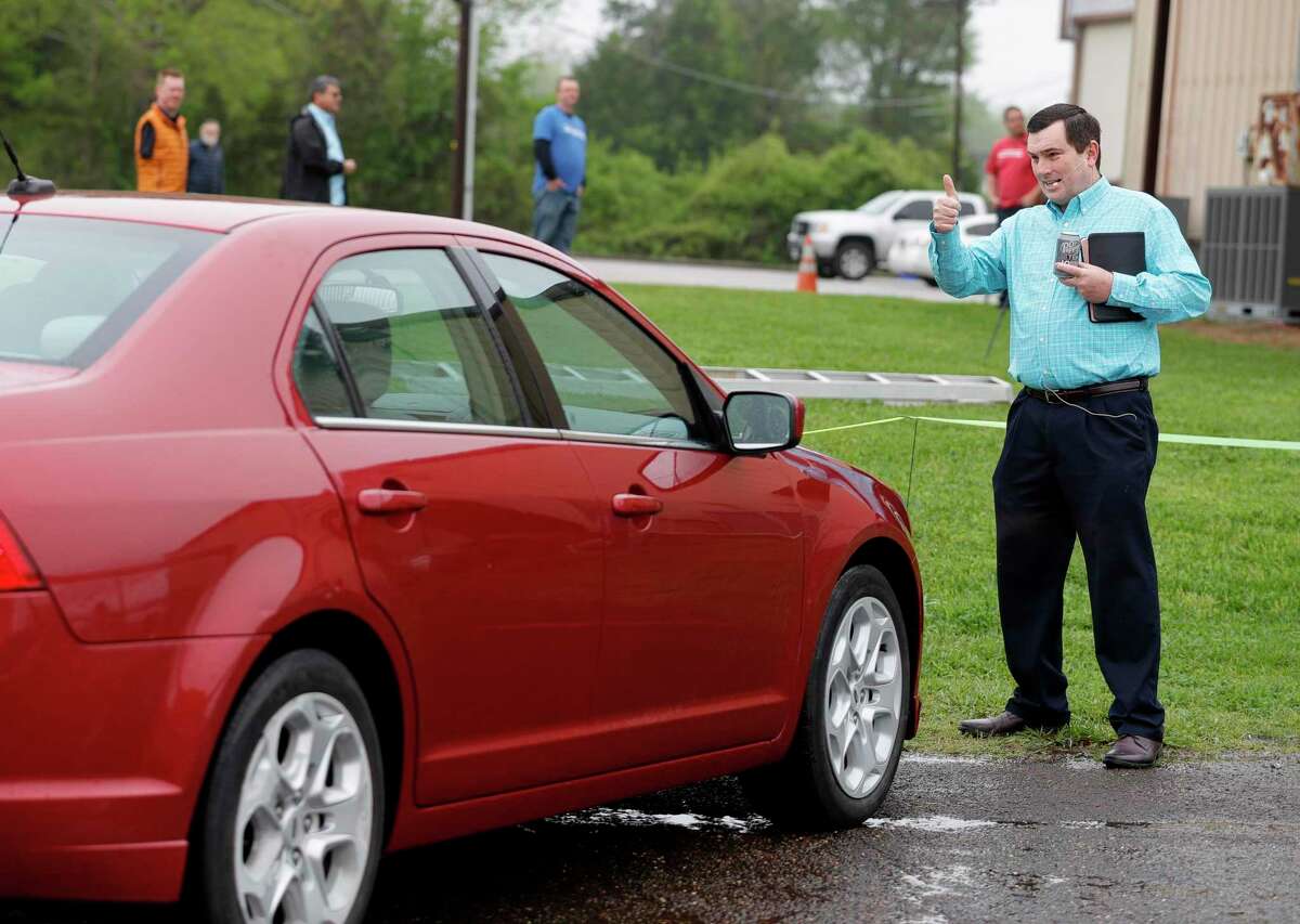 Pastor Chris Gober gives a thumbs-up after helping to direct a parishioner’s car into place before a drive-in style service at First Montgomery Baptist Church, Sunday, March 22, 2020, in Montgomery. More than 200 parishioners attended the service.