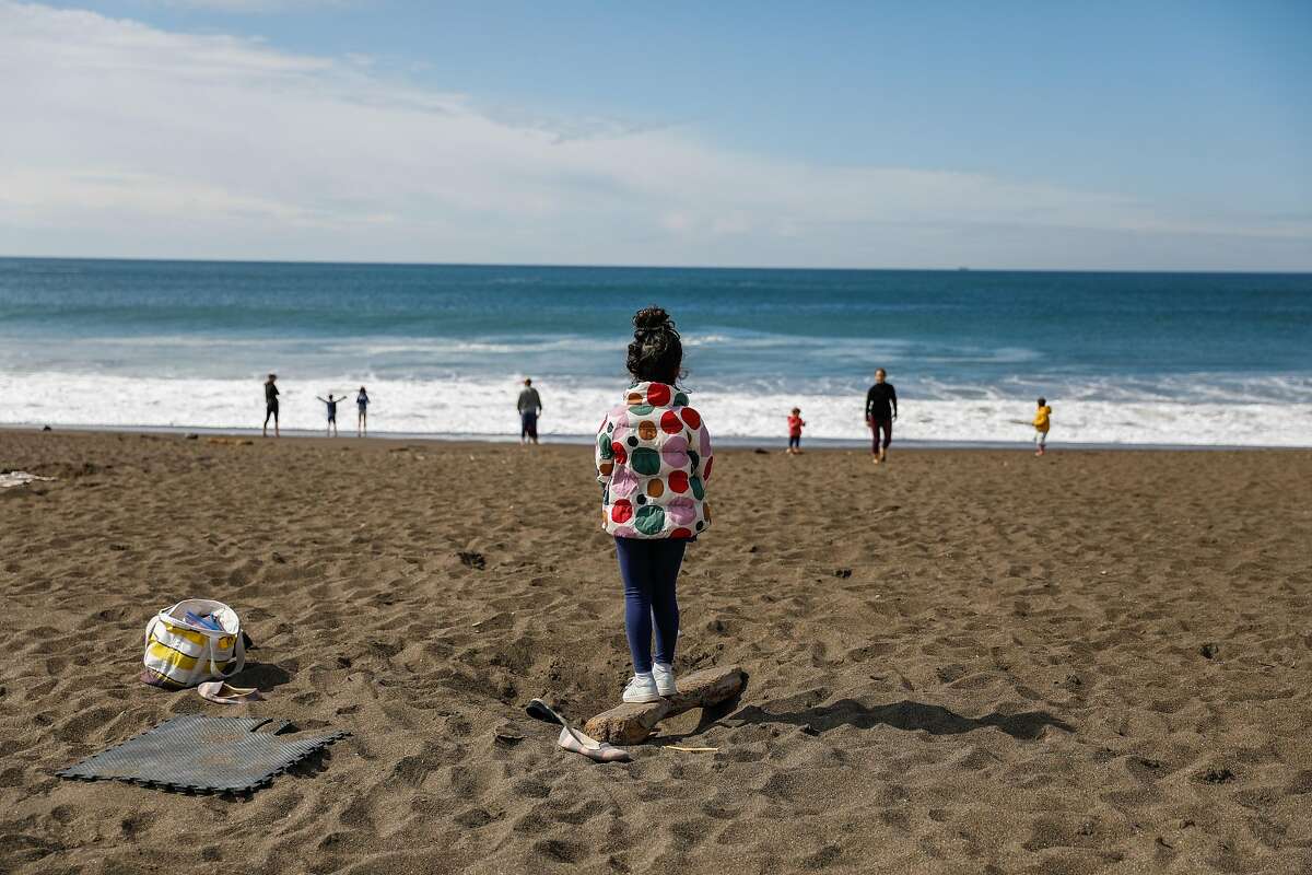 People try to maintain social distancing during the shelter-in-place orders at Rodeo beach on Sunday, March 22, 2020 in Marin County, California.