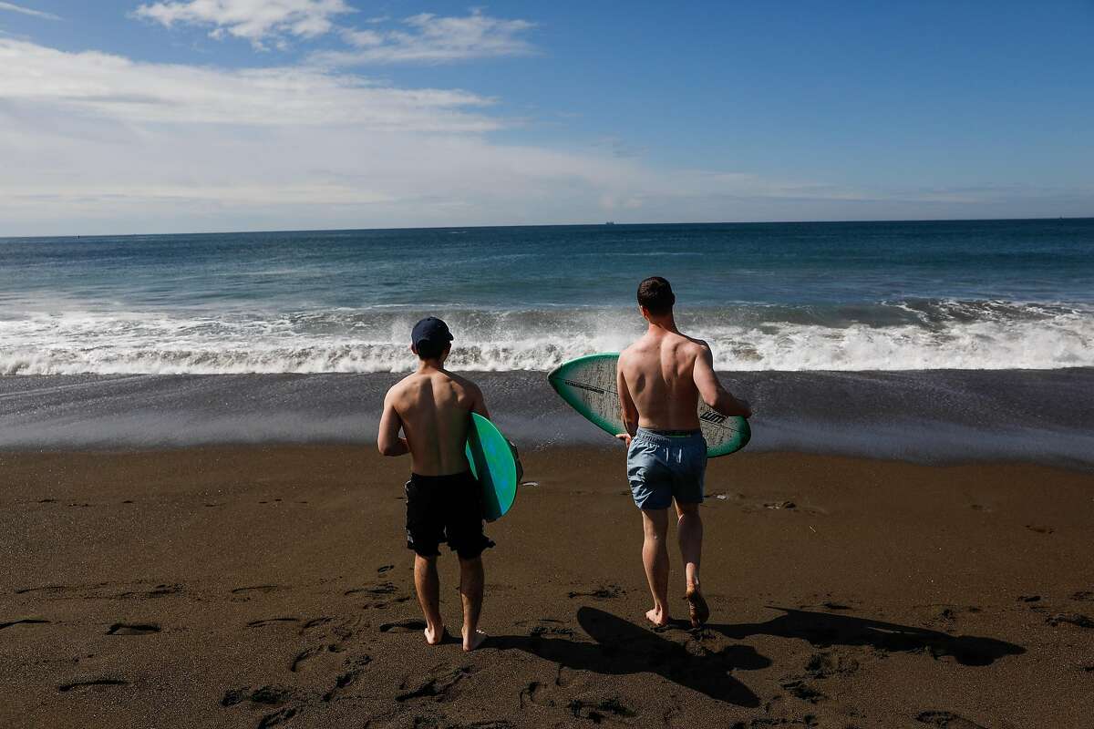 Travis Lateef and Red Ongaro (right) wakeboard during the shelter-in-place orders at Rodeo beach on Sunday, March 22, 2020 in Marin County, California.