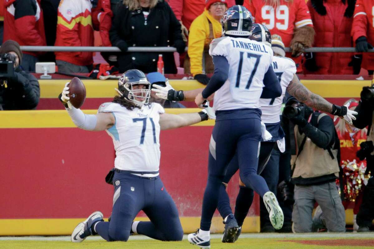 Tennessee Titans' Dennis Kelly (71) celebrates his touchdown catch with quarterback Ryan Tannehill (17) during the first half of the NFL AFC Championship football game against the Kansas City Chiefs Sunday, Jan. 19, 2020, in Kansas City, MO. (AP Photo/Charlie Riedel)