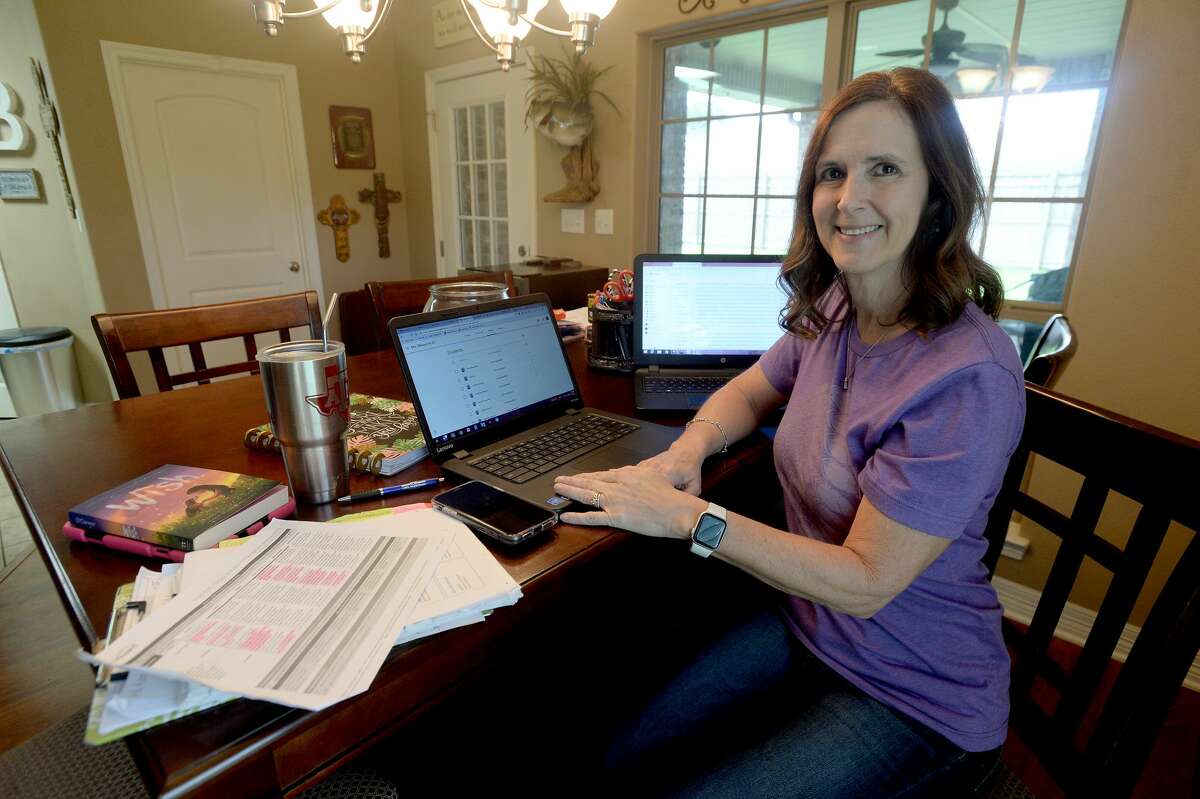 Tracie Billeaud, a third grade teacher at Ridgewood Elementary School in Port Neches, sits at her home-based teaching set-up. Billeaud says her students are excited to continue learning, and as of late Friday all have now been able to get signed in and access the site, which includes a group chat area where they can communicate with her and one another. She even has shown them a photo of their class fish "Cosmo," whose bowl now sits among her computers, books and papers.
