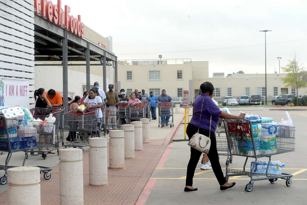A line of shoppers await admittance outside the H-E-B store on College Street in Beaumont Thursday morning. Long lines gathering for store openings is becoming a morning routine, with shoppers hoping to get restocked items, especially paper products, cleaning supplies and non-perishables, before they quickly fly off the shelves. Photo taken Thursday, March 19, 2020 Kim Brent/The Enterprise