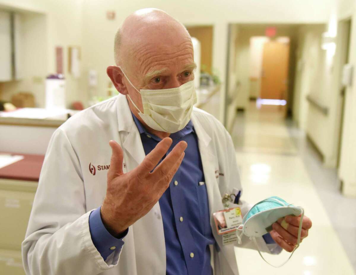Stamford Hospital Chair of Infectious Diseases Dr. Michael Parry demonstrates a string mask while speaking about the coronavirus at Stamford Hospital in Stamford, Conn. Thursday, March 4, 2020. The hospital has been preparing to handle coronavirus patients by stocking up on supplies and establishing a coronavirus protocol.