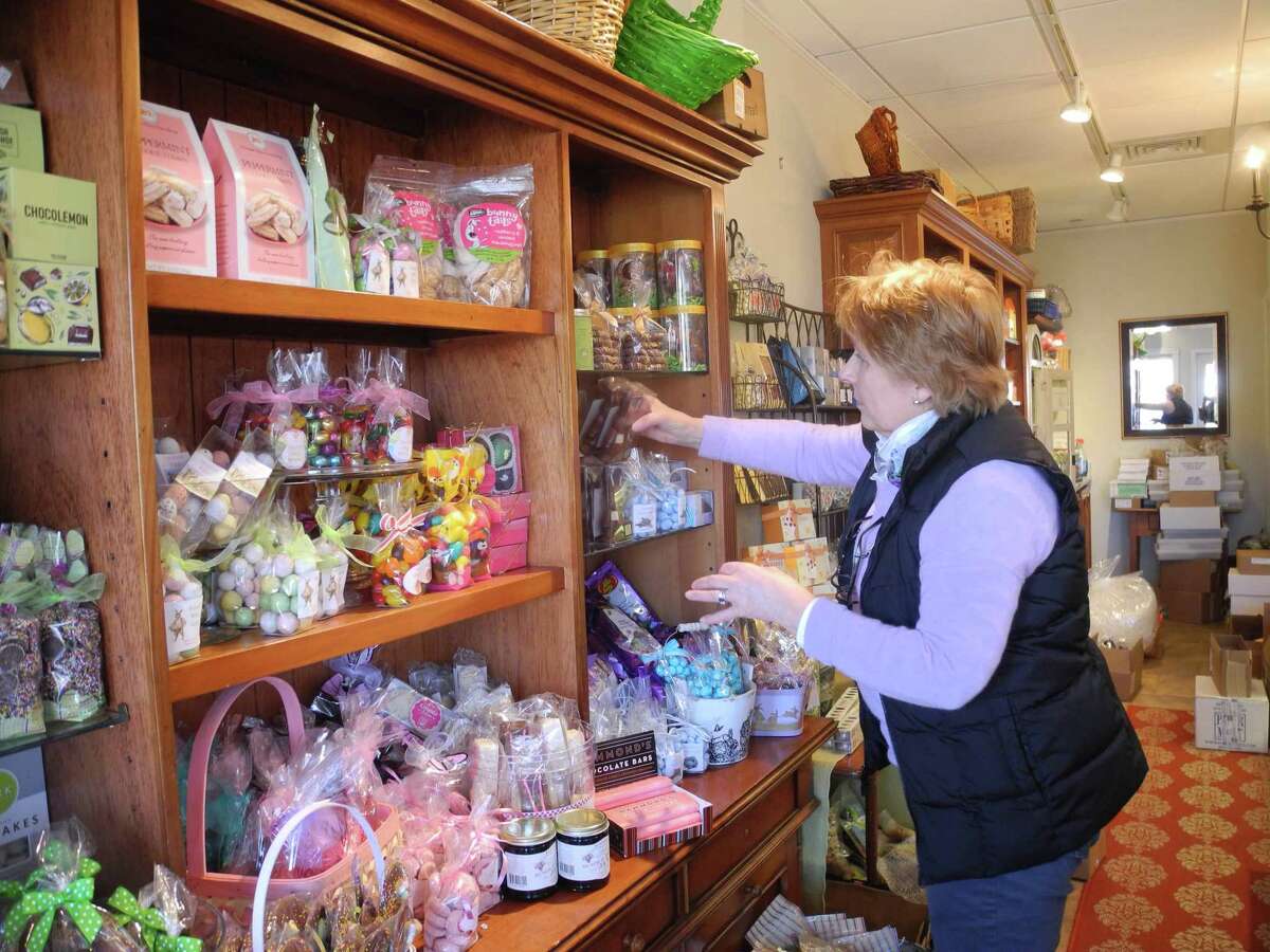 Nancy Saxe stocks the shelves at Sweet Pierre’s in River Park Plaza, one of the businesses in town that’s open.