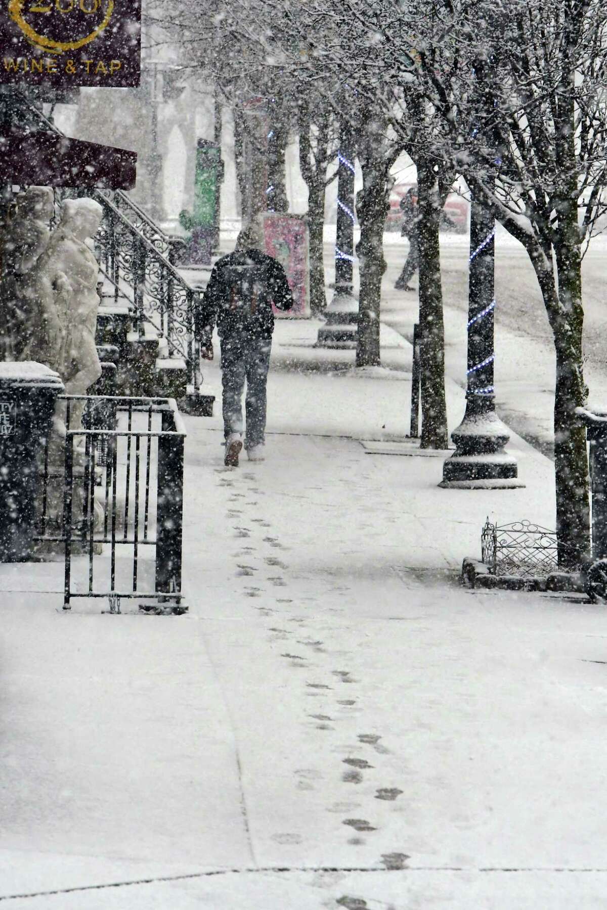 A pedestrian walks down a sidewalk on Lark St. in the snow on Monday, March 23, 2020 in Albany, N.Y. (Lori Van Buren/Times Union) ORG XMIT: j=032420_weather
