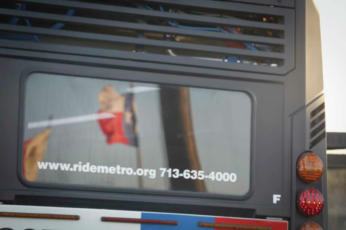 A Texas flag is reflected in the rear window of a Metropolitan Transit Authority bus on Feb. 26, 2020, in Houston.