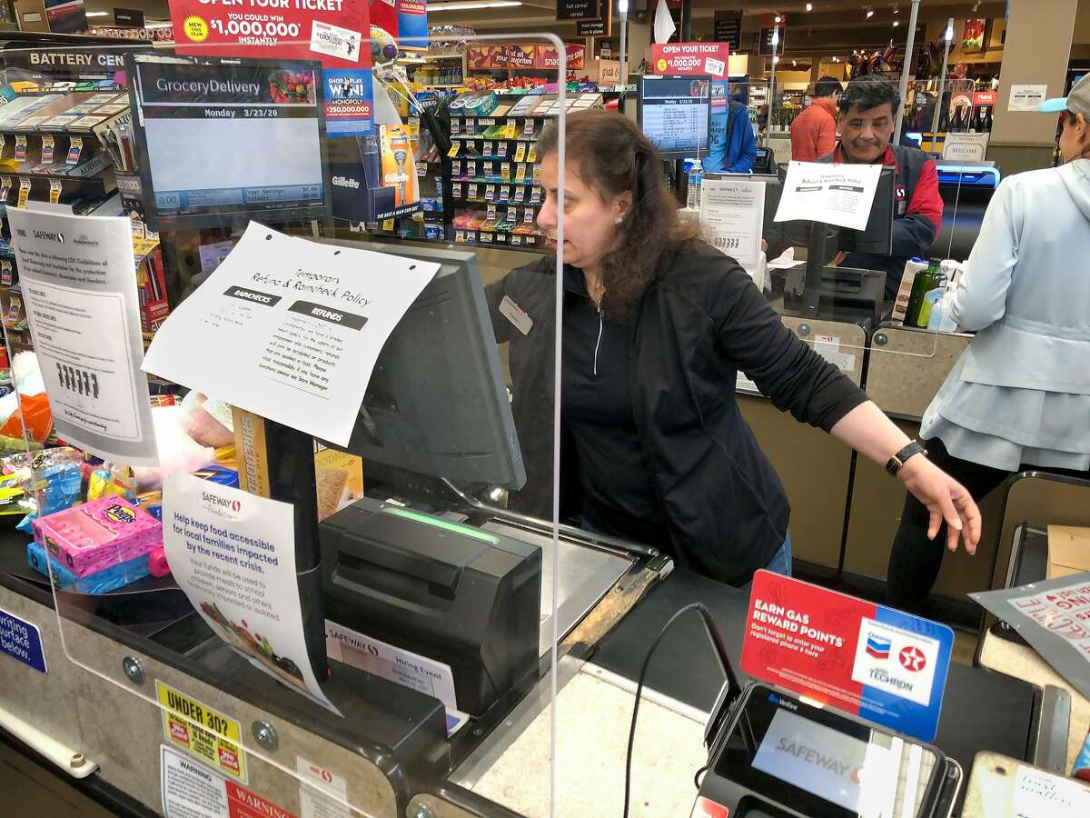 New plexiglass screens keep checkers and customers more safe from the spread of coronavirus at the Crystal Springs Village Safeway Monday, March 23, 2020, in San Mateo, Calif.