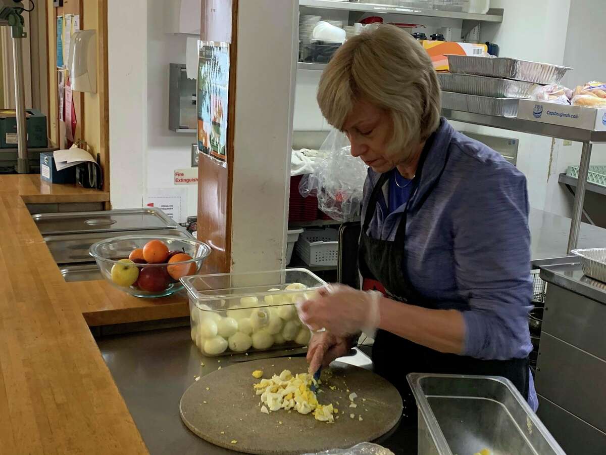 Deb Plaver cuts boiled eggs in preparation for the next day at the Midland Open Door's soup kitchen on March 23, 2020. (Mitchell Kukulka/Mitchell.Kukulka@mdn.net)