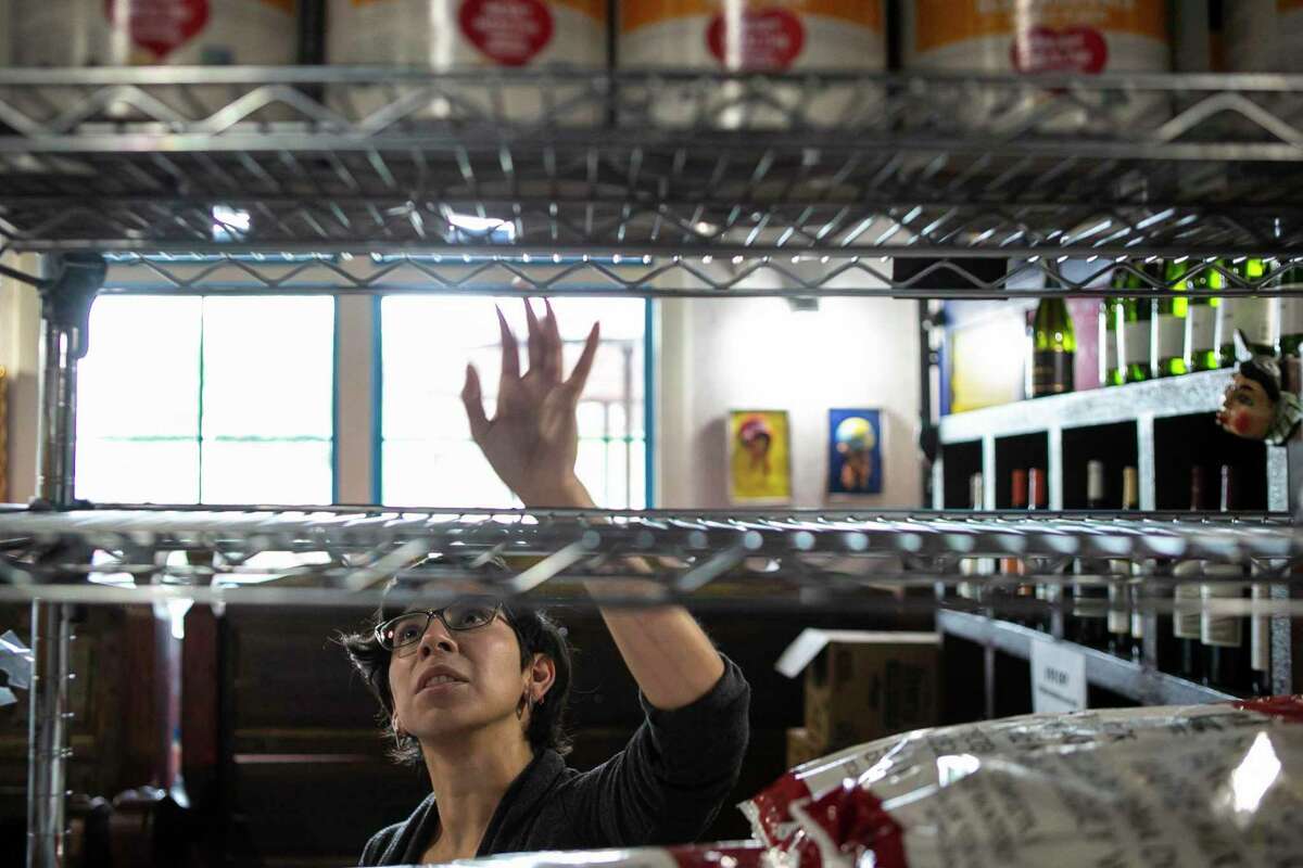 Linda Torres stocks shelves at La Gloria in San Antonio, Texas, on March 23, 2020. Some local restaurants have created makeshift grocery stores amid coronavirus related shut downs.
