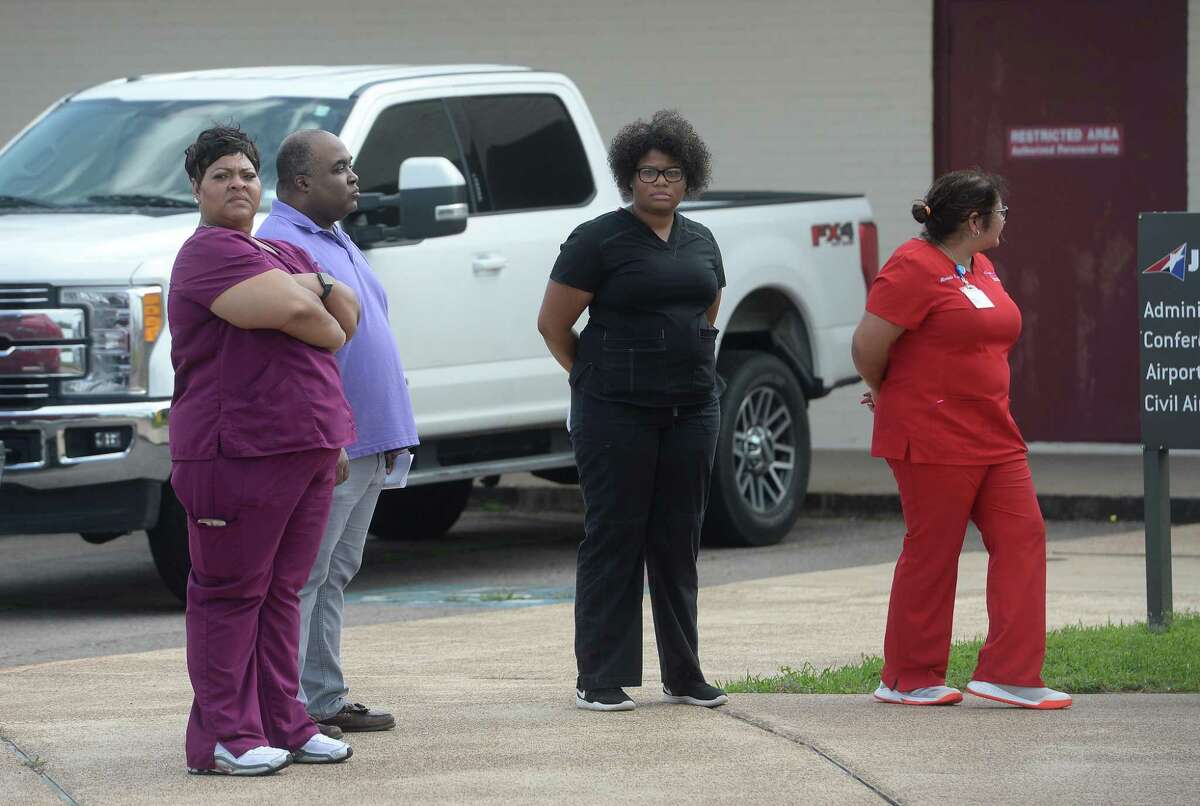 Medical personnel gather with officals as representatives from multiple Southeast Texas counties annnounce the opening of a drive-thru testing unit for COVID-19 at Jack Brooks Regional Airport Monday. Photo taken Monday, March 23, 2020 Kim Brent/The Enterprise
