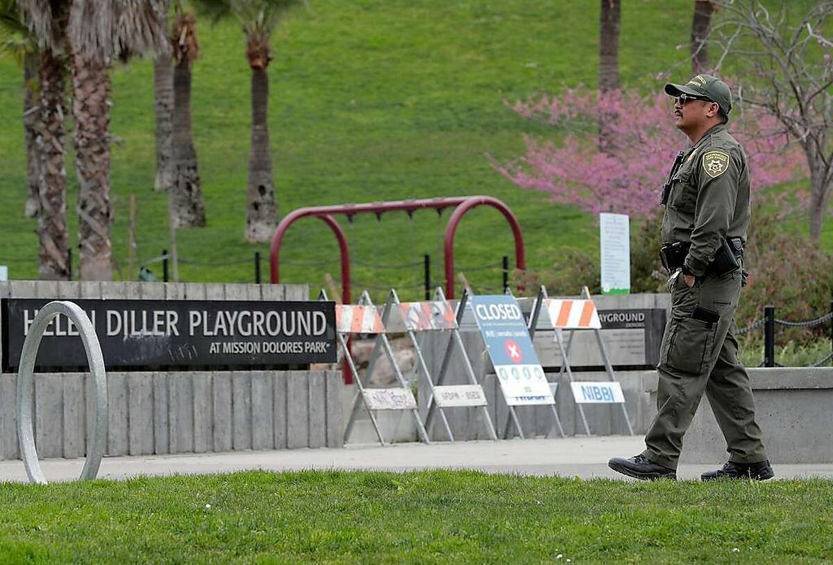 Park Ranger Mariano keeps a watch at the closed Helen Diller Playground in Dolores Park following Mayor London Breed’s decision to have city parks close children’s playgrounds to prevent the spread of the coronavirus in San Francisco, Calif., on Monday, March 23, 2020.