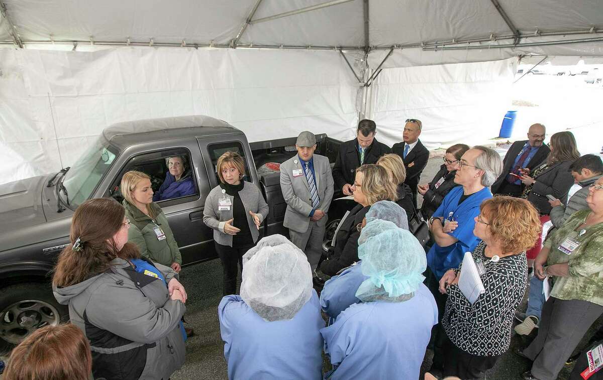 Nurse leader Karen Fasano gives instruction to medical personnel while practicing drive-through testing for the coronavirus at MidState Medical Center in Meriden, Conn., on March 17, 2020.