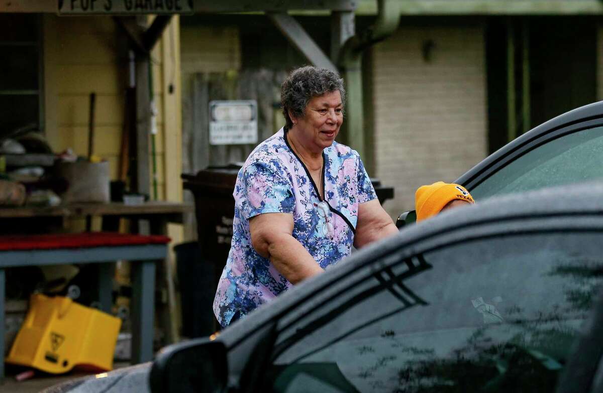 Mary Morris pushes one of her clients toward a taxi cab before going to a doctor's appointment Friday, March 20, 2020, in South Houston, Texas. More than a million sick and elderly Texans rely on home health attendants, like Morris. These caregivers are some of the most burdened in the health care industry; making little above minimum wage, often have multiple jobs, no paid sick leave, and are caring for the people most vulnerable to Covid-19.