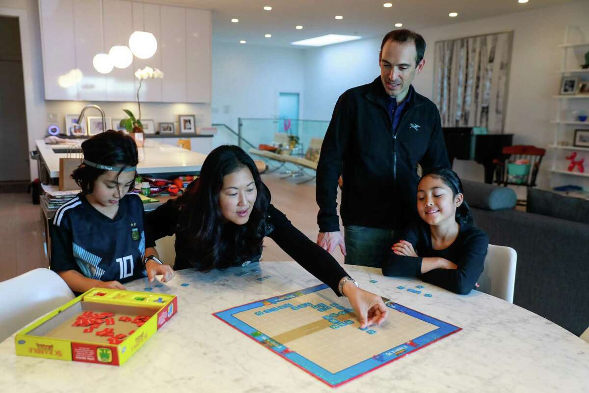Ethan Ellis,6, mom Youjeong Kim, dad Ben Ellis and sister Emmy Ellis, 8 play scrabble at their dining room table at their home on Monday, Dec. 23, 2019 in San Francisco, California.