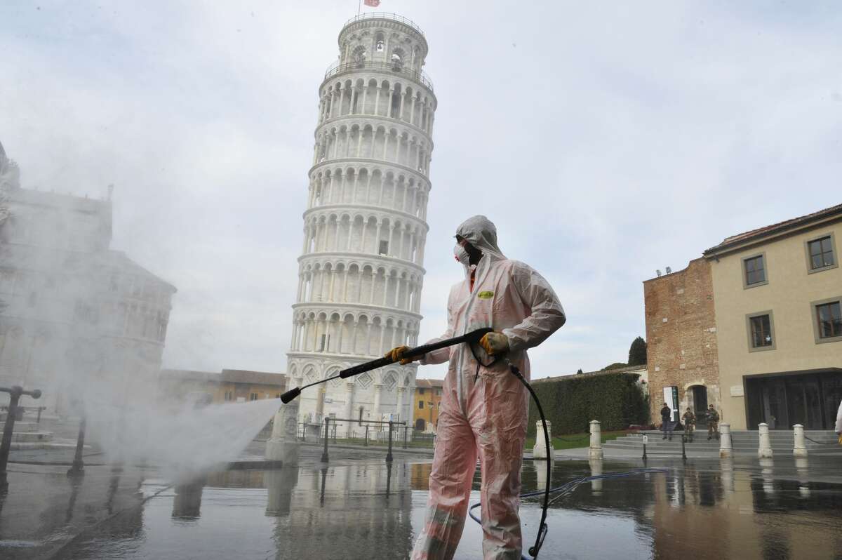 PISA, ITALY - MARCH: A worker carries out sanitation operations for the Coronavirus emergency in Piazza dei Miracoli near to the Tower of Pisa in a deserted town on March 17, 2020 in Pisa, Italy. The sanitization service is carried out by four teams in all the districts of the city of Pisa, to sanitize the squares, streets, public areas, sidewalks, surfaces exposed to the contact of large flows of people. Italian government has imposed unprecedented restrictions on its 60 million people as it expanded its emergency Coronavirus (Covid-19) lockdown nationwide. The number of confirmed Covid-19 cases in Italy has passed 31,500 with the death toll rising to 2503. (Photo by Laura Lezza/Getty Images)