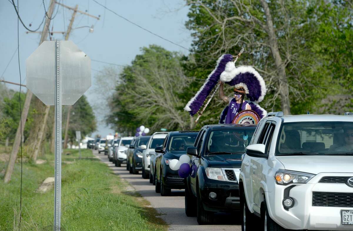 The Indian Spirit cheers as Port Neches Elementary School teachers parade through the city waving to students and their families who gathered on lawns and curbs to greet them. Principal Kim Carter organized Tuesday's parade after seeing a similar event on social media. Teachers, their children and the Indian Spirit rode in cars decorated with signs, and one with a gigantic teddy bear popping up through the top of a Jeep. Photo taken Tuesday, March 24, 2020 Kim Brent/The Enterprise