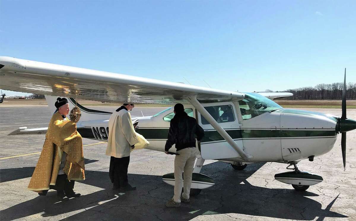 The Rev. Brian Gannon, pastor of St. Theresa’s Roman Catholic Church in Trumbull and the Rev. Flavian Bejan, associate pastor enter the Cessna 172 airplane at Sikorsky Memorial Airport before flying over the Bridgeport Diocese to bestow blessings Tuesday afternoon.