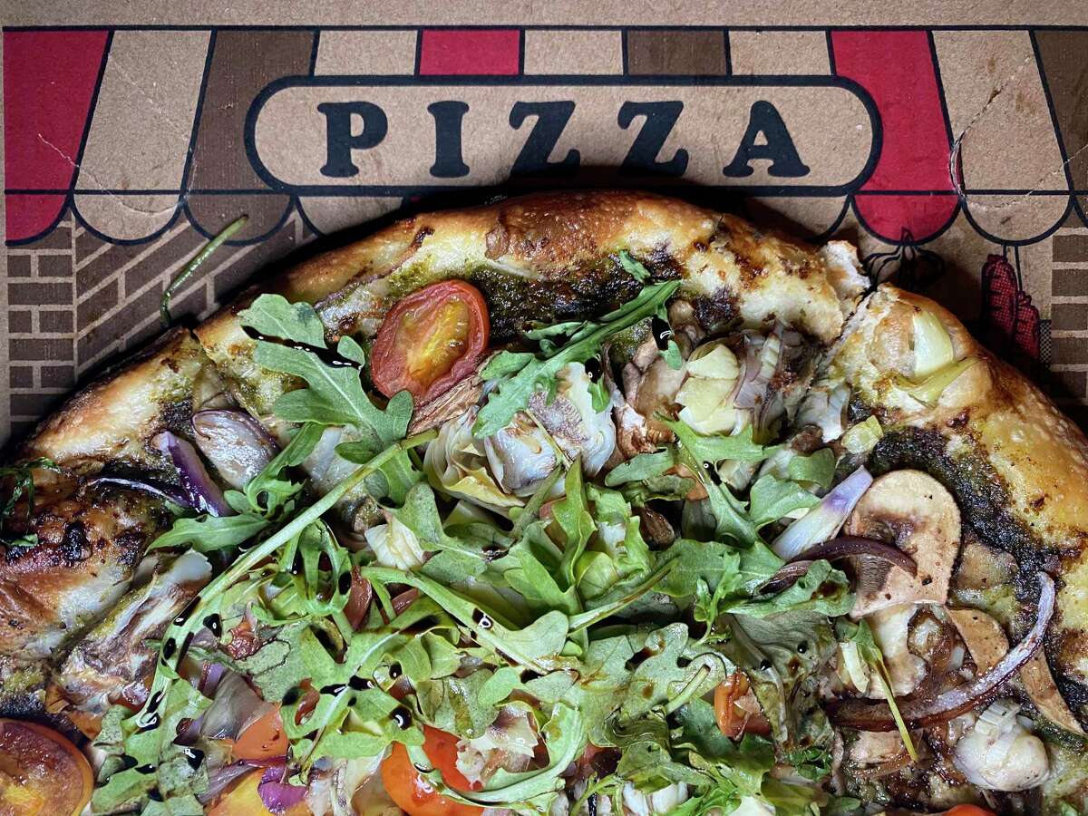 The Screaming Vegan pizza incorporates basil pesto, red onions, mushrooms, cherry tomatoes, artichokes and arugula, drizzled with a balsamic vinegar reduction at The Last Slice.