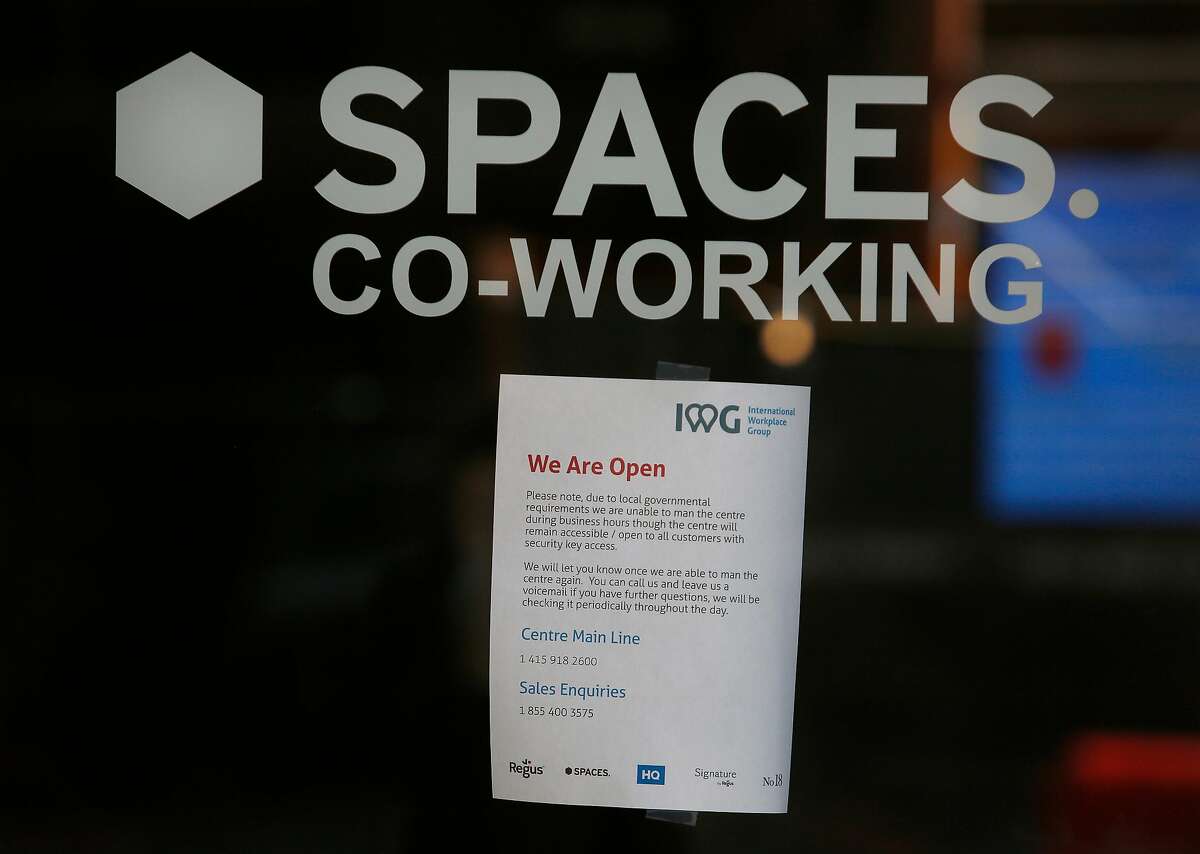 A sign on the door at Spaces at 95 Third Street alerts people to changes due to local governmental requirements on Wednesday, March 25, 2020 in San Francisco, Calif.